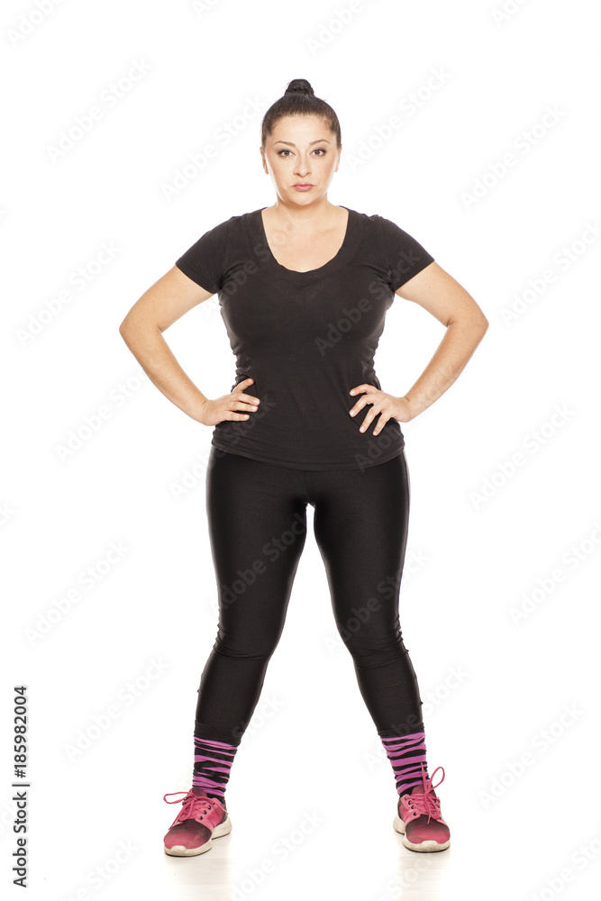 Fototapeta premium Chubby woman posing in fitness clothing on white background