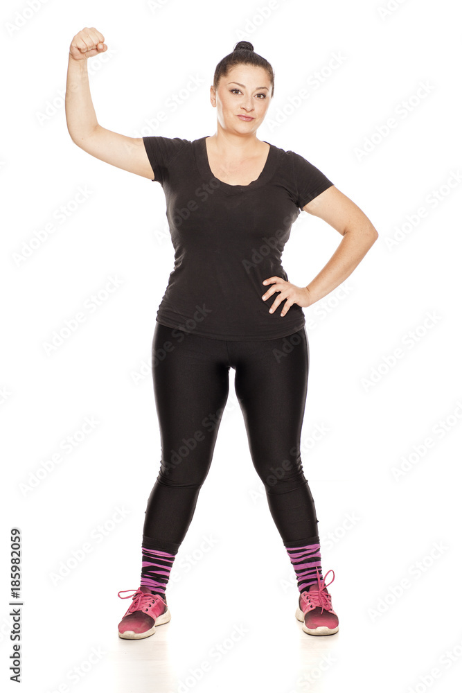 Fototapeta premium Chubby woman posing in fitness clothing on white background