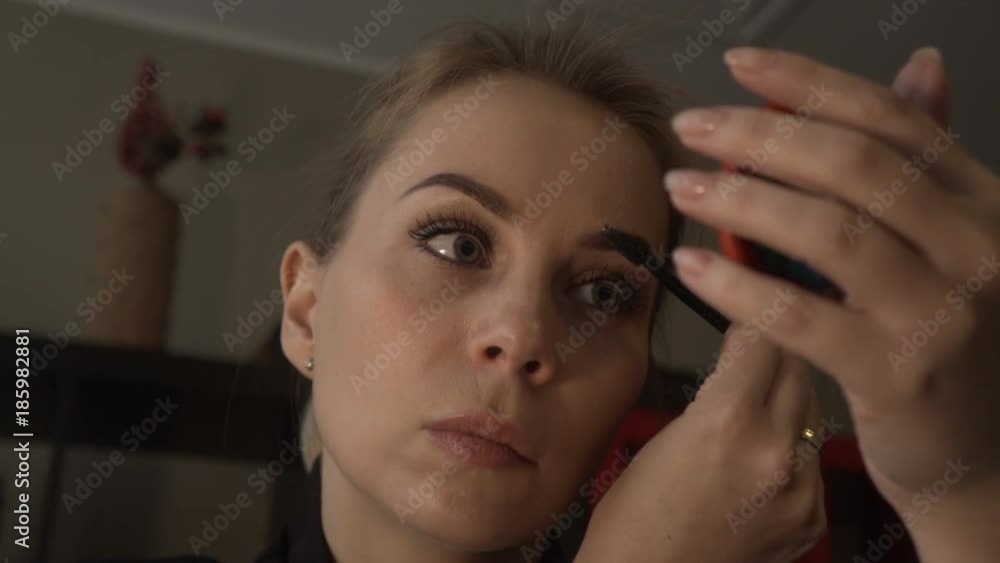 Portrait attractive woman using cosmetic brush for make up eyebrows Portrait attractive woman using cosmetic brush for make up eyebrows