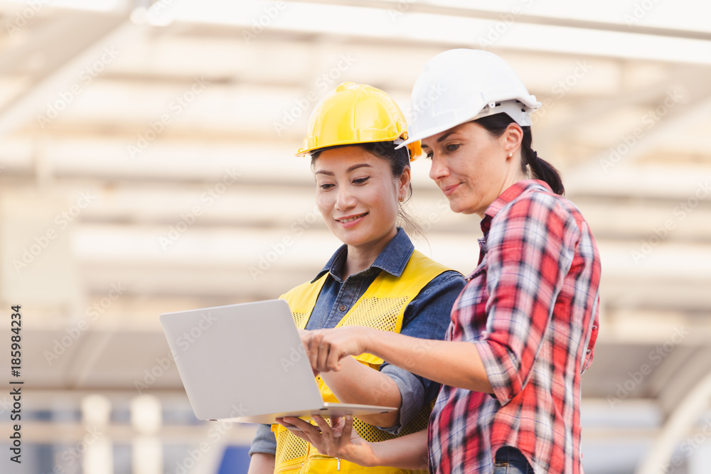 Engineers two woman working on plan building construction with laptop in city Engineers two woman working on plan building construction with laptop in city