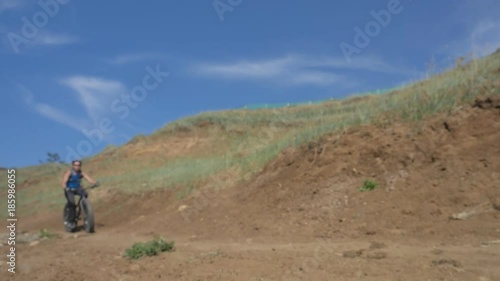 Wallpaper Mural Fat bike also called fatbike or fat-tire bike in summer driving on the road. The guy rides by the hill on a sand clay path. The bicycle is allowed into the drift. Slow motion shooting 180fps. Torontodigital.ca