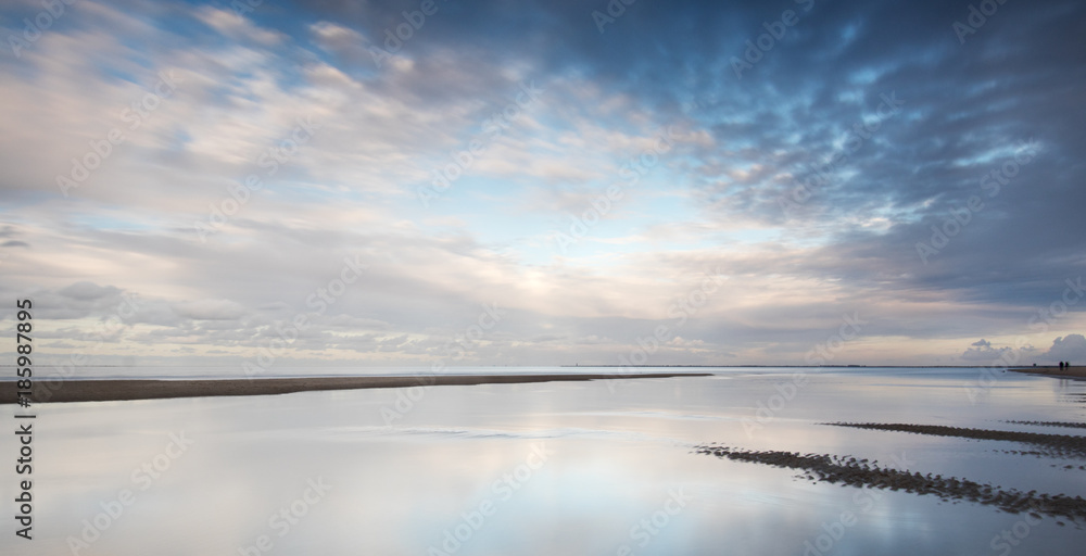 Clouds at Dutch beach with reflections