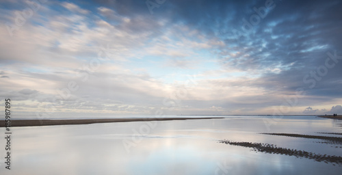 Clouds at Dutch beach with reflections