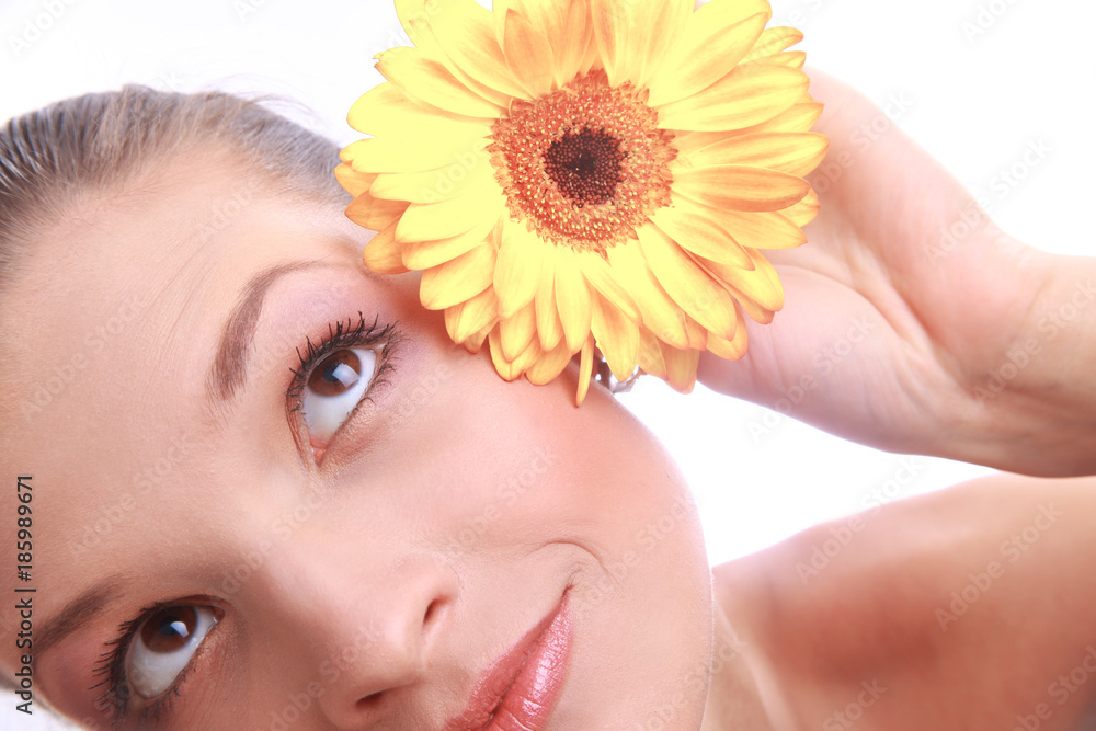 Young beautiful woman with yellow flower isolated on white Young beautiful woman with yellow flower isolated on white
