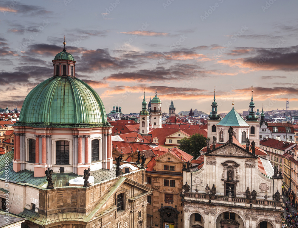 Top view of the roofs of Prague, with red tiled roofs and statues, spires and towers protruding, Czech Republic