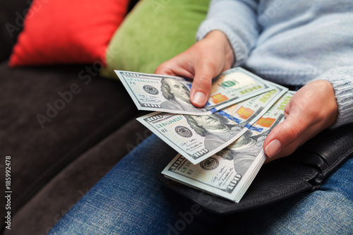 money in hands for a girl sitting on a sofa