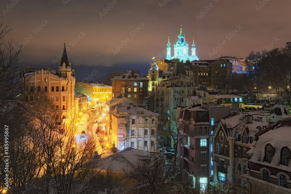 View of the Andreevsky Descent and St. Andrew's Church at background in winter evening. The street, often advertised by tour guides and operators as 