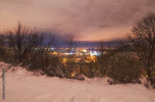 Amazing evening cityscape of Podil Podol  district at winter. River Dnieper and unfinished Podolsko-Voskresenskij bridge. Kyiv  Ukraine