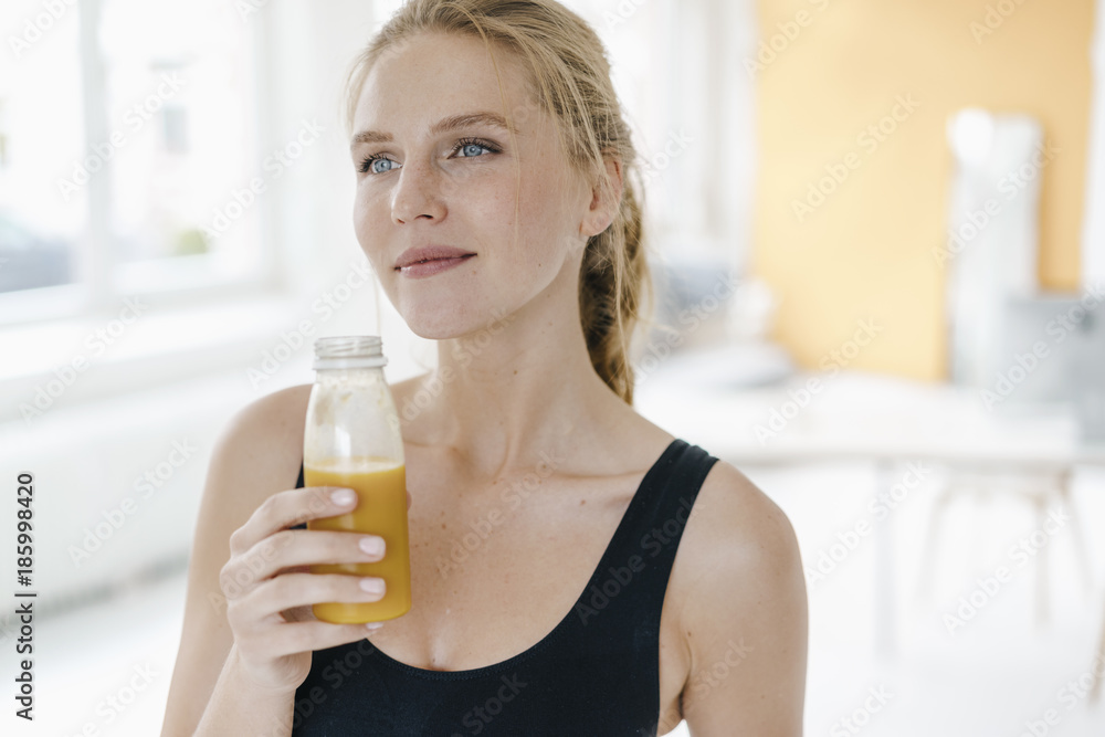 Portrait of smiling young woman in sportswear drinking a smoothie Portrait of smiling young woman in sportswear drinking a smoothie