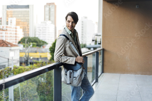 Young man standing on urban balcony photo