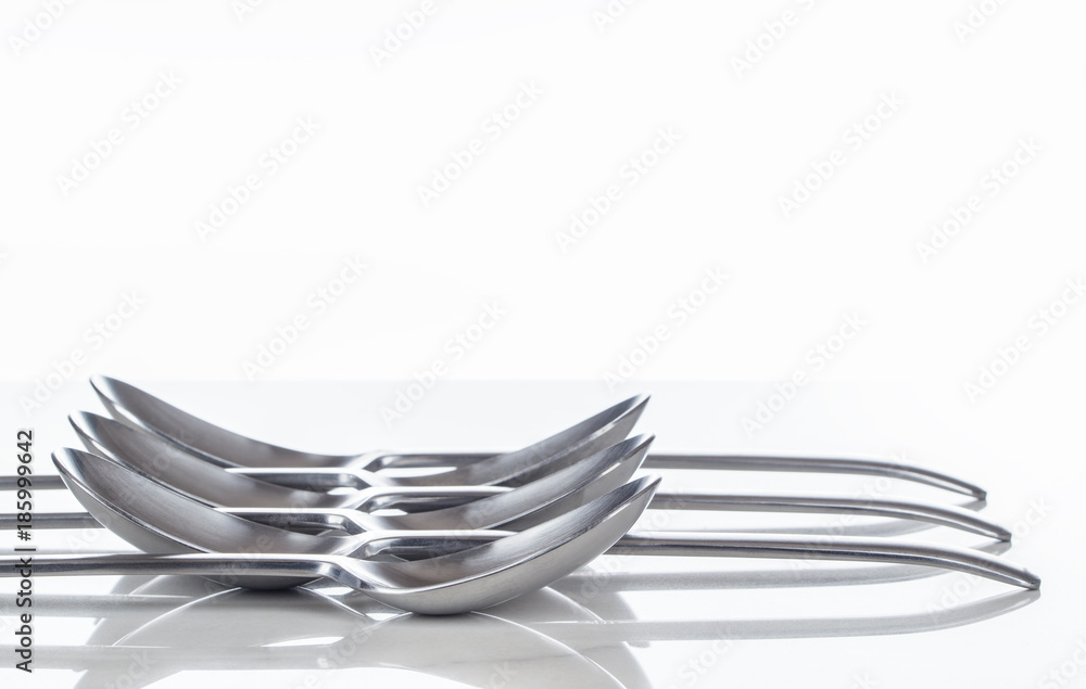 Kochen, Geschirr, Besteck, Löffel in Reihe auf spiegelnder Tischplatte, Hintergrund Kochen, Geschirr, Besteck, Löffel in Reihe auf spiegelnder Tischplatte, Hintergrund