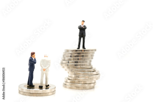 Miniature toy: Business man discussing about business on stack of coin and one man thinking how to success like that man, business ,financial, Success, Business Growth concept.
