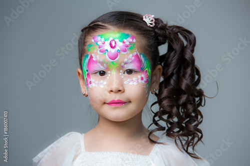 Portrait of an Asian-looking girl with a painted lyu. Face painting