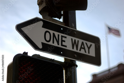One way sign with american flag in the background