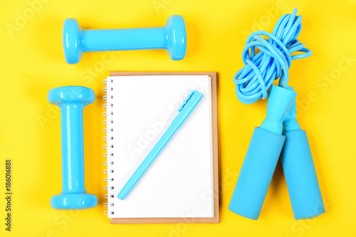 Notepad and fitness tools. Notebook, pen and gym equipment