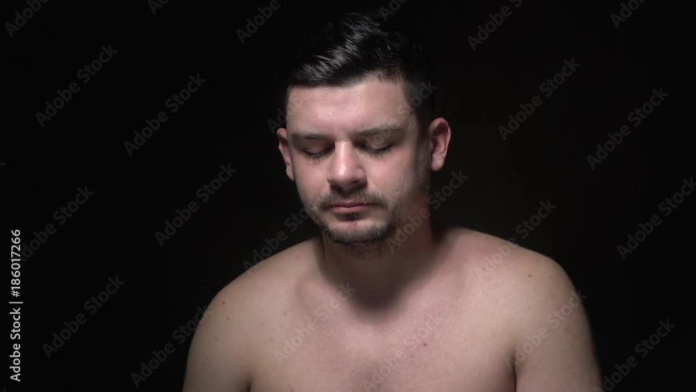 Pensive bearded man sits on a dark background Pensive bearded man sits on a dark background