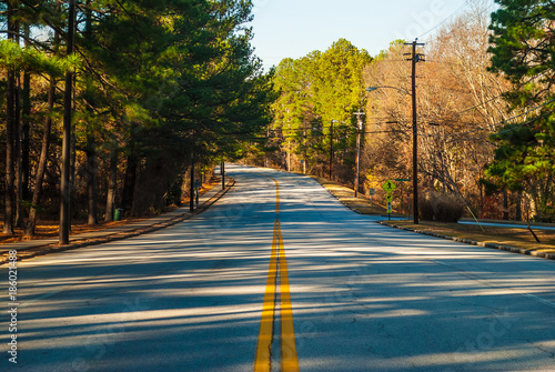 Robert E Lee Boulevard with long shadows of trees in the Stone Mountain Park in sunny autumn day, Georgia, USA
