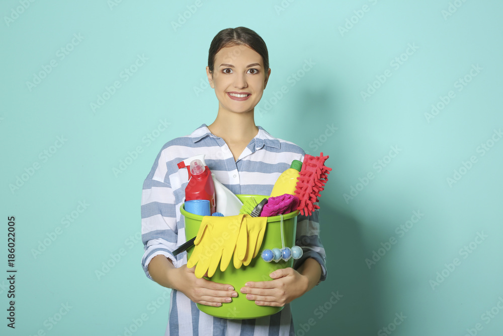 Woman with cleaning supplies on color background Woman with cleaning supplies on color background