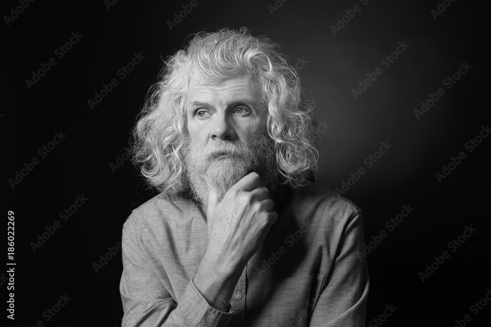 Senior man in casual clothes on dark background, black and white effect