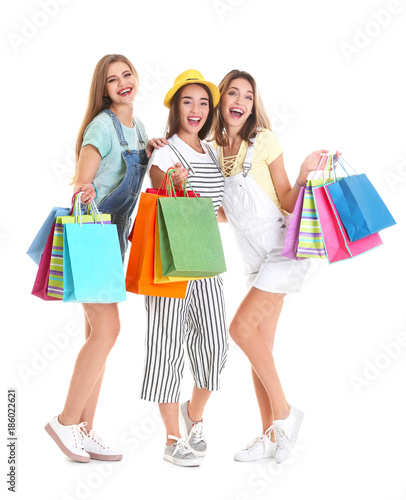 Happy young women with shopping bags on white background