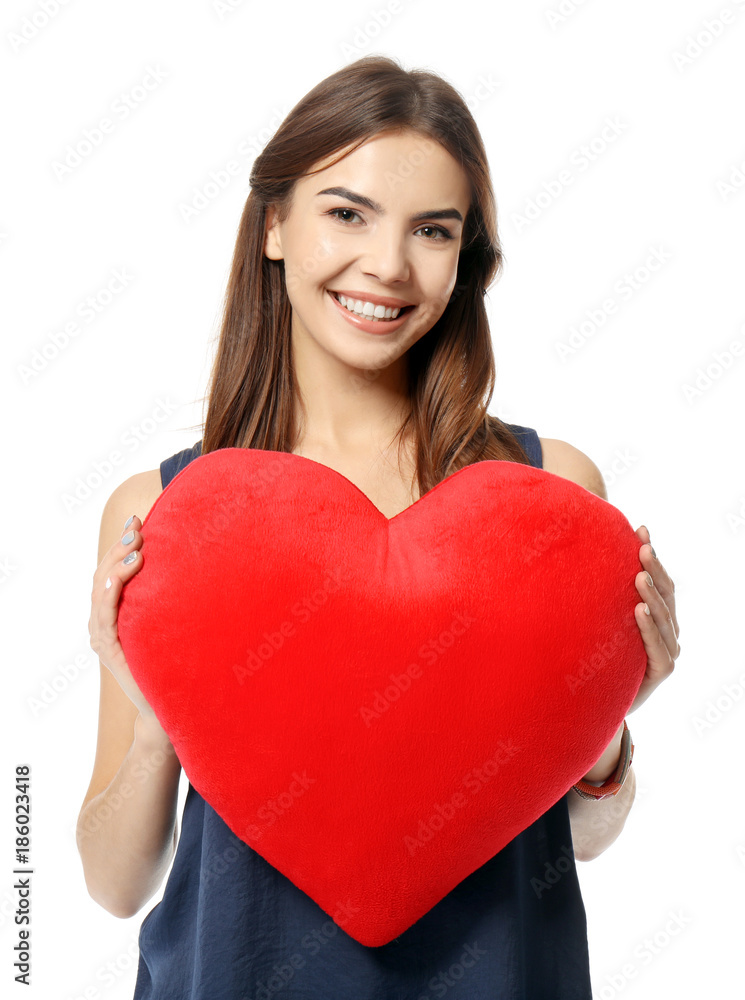 Romantic young woman with heart-shaped pillow on white background Romantic young woman with heart-shaped pillow on white background