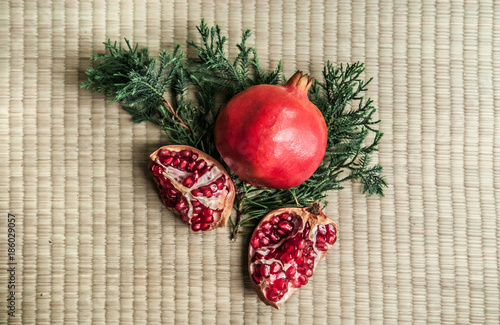 Fototapeta Naklejka Na Ścianę i Meble -  Ripe pomegranate fruit isolated on tatami background, top angle