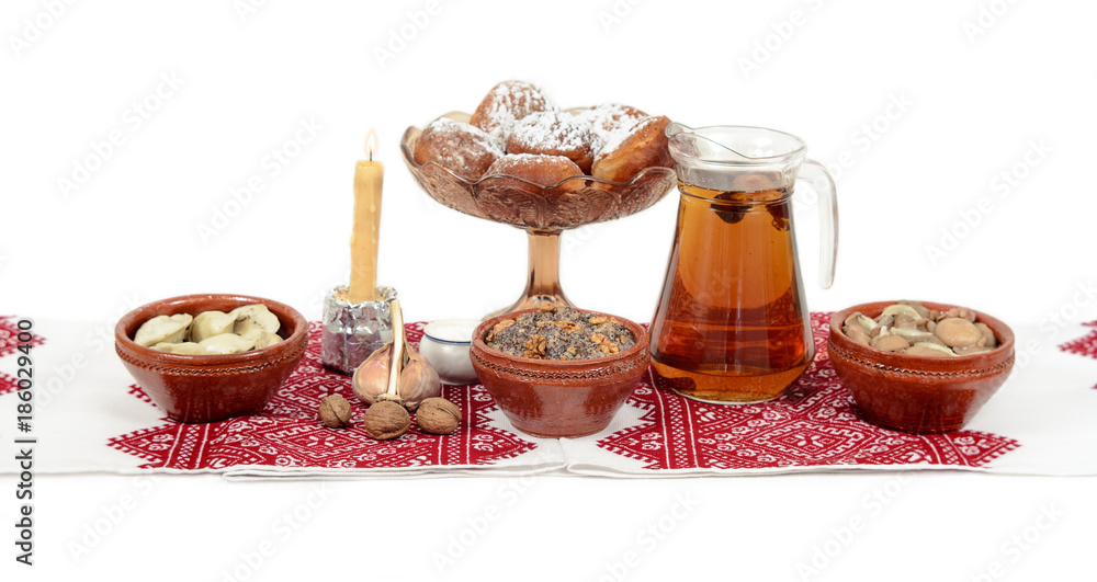 Traditional Christmas treat of the Slavs on Christmas eve. Slavic food kutia, uzvar, varenyky, pyrogy, muchrooms, candle on white background