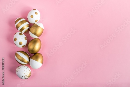 Obraz na płótnie Top view of easter eggs colored with golden paint. Various striped and dotted designs. Pink background. w salonie