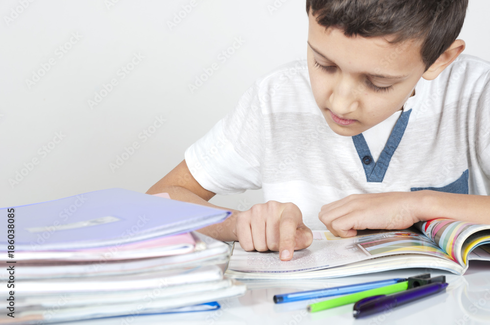 boy is sitting at desk doing his homework boy is sitting at desk doing his homework