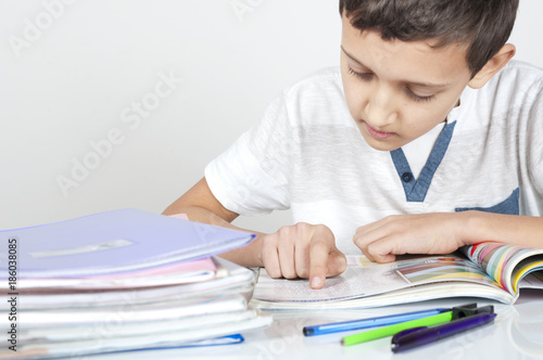 boy is sitting at desk doing his homework