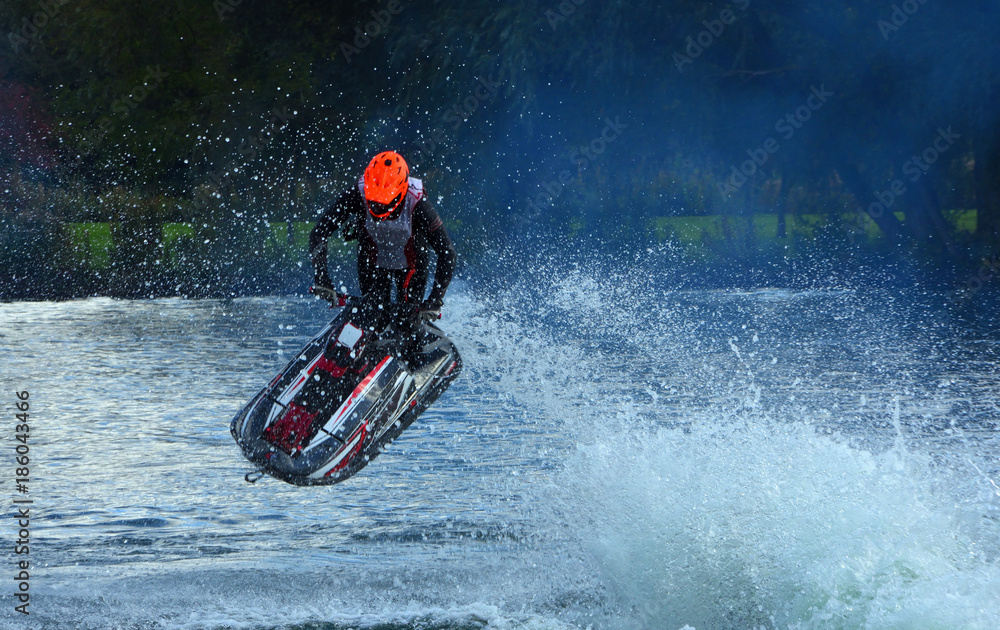 Freestyle Jet Skier performing Jump  creating at lot of spray.