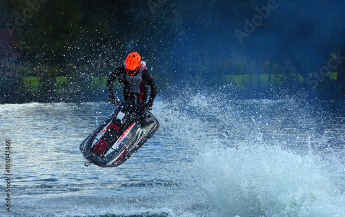 Freestyle Jet Skier performing Jump creating at lot of spray.