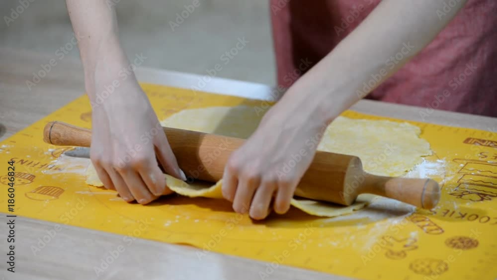 Woman's hands roll the dough. Woman's hands roll the dough.