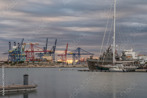 shipping, maritime logistics port harbor cranes working loading transport ships, twilight reflection in water