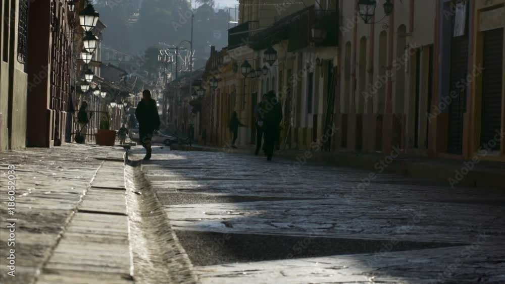 sunny morning people in silhouette wolking on colonial street in ancient town San Cristobal de las Casas sunny morning people in silhouette wolking on colonial street in ancient town San Cristobal de las Casas