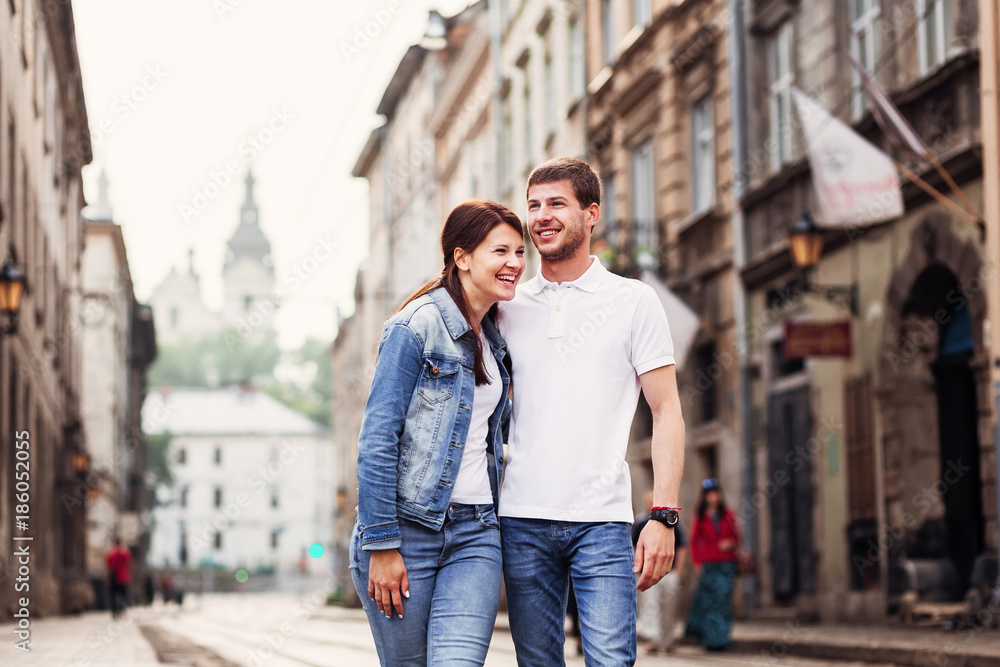 A pair of two lovers of people laughs while walking around the city A pair of two lovers of people laughs while walking around the city