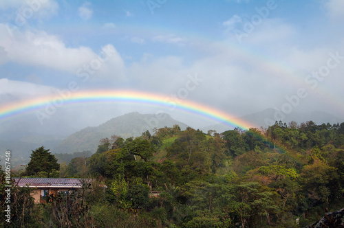 Double rainbow in Boquete in western Panama. Mixed clouds  light rain  and blue sky.
