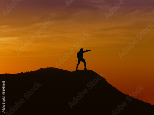 Silhouette young man standing on the mountain.
