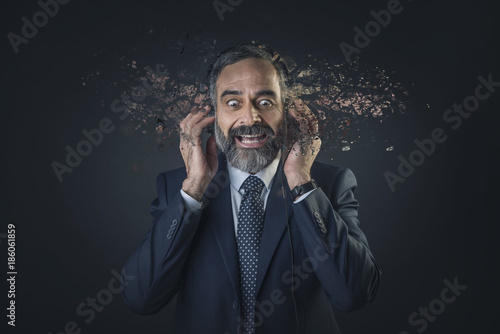 Senior old business man's head exploding while listening to some fantastic music