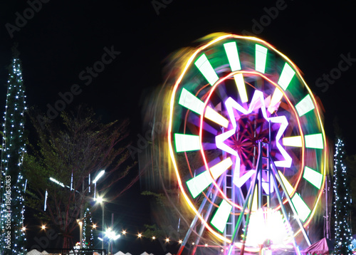 Abstract moving light from ferris wheel at night time.