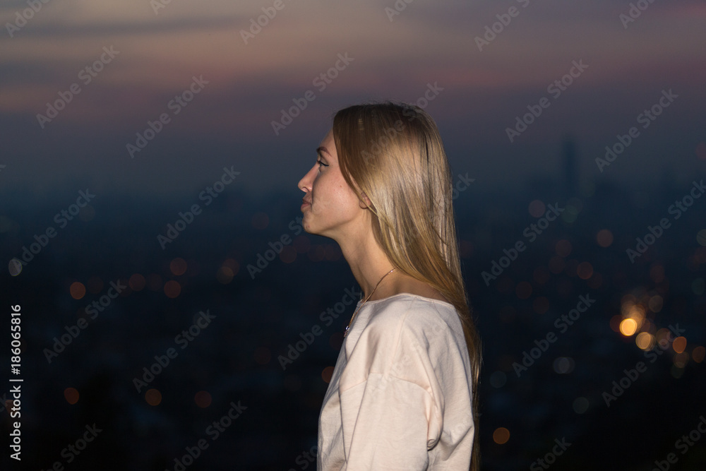 Portrait of young attractive caucasian woman during night with city background. Portrait of young attractive caucasian woman during night with city background.