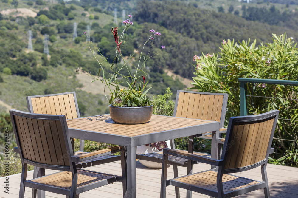 Outdoor terrace with seating arrangement, table, chairs and flowerpot in wood.