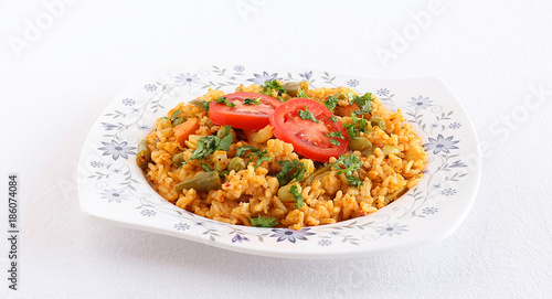 Tomato rice pilaf or tomato rice bath, an Indian vegetarian breakfast, with garnishing of fresh tomato slices and coriander leaves.