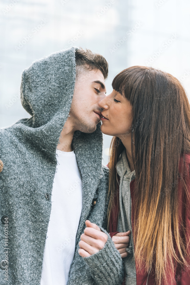 Young beautiful in love couple holding each other in the middle of the street in a romantic way . Young beautiful in love couple holding each other in the middle of the street in a romantic way .