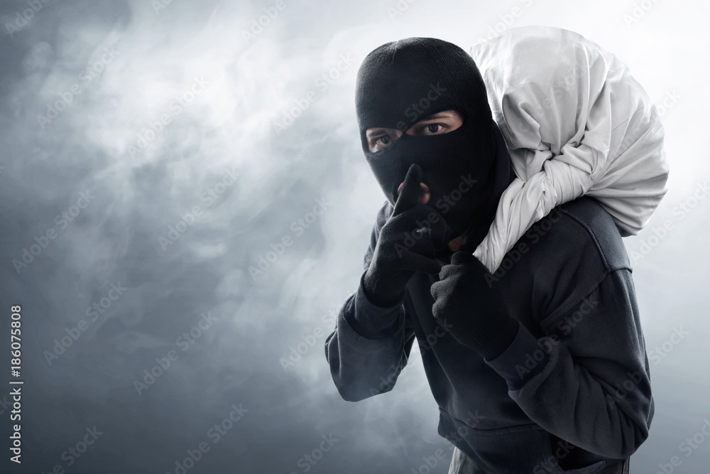 Masked thief stealing Stock Photo | Adobe Stock