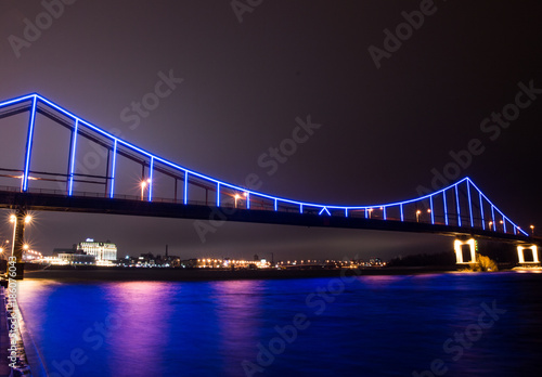 Multicolored bridge over the river at night photo