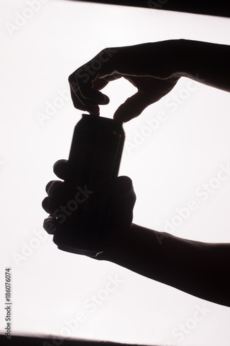 Silhouette of a jar and a glass in hands