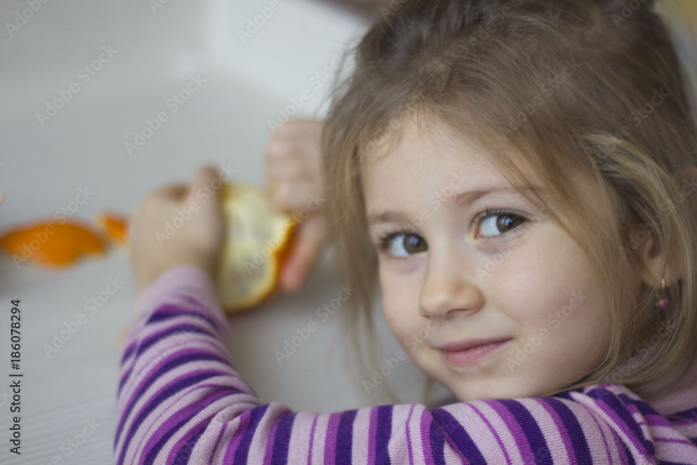 Fototapeta premium Child and tangerine, orange. Selective focus.