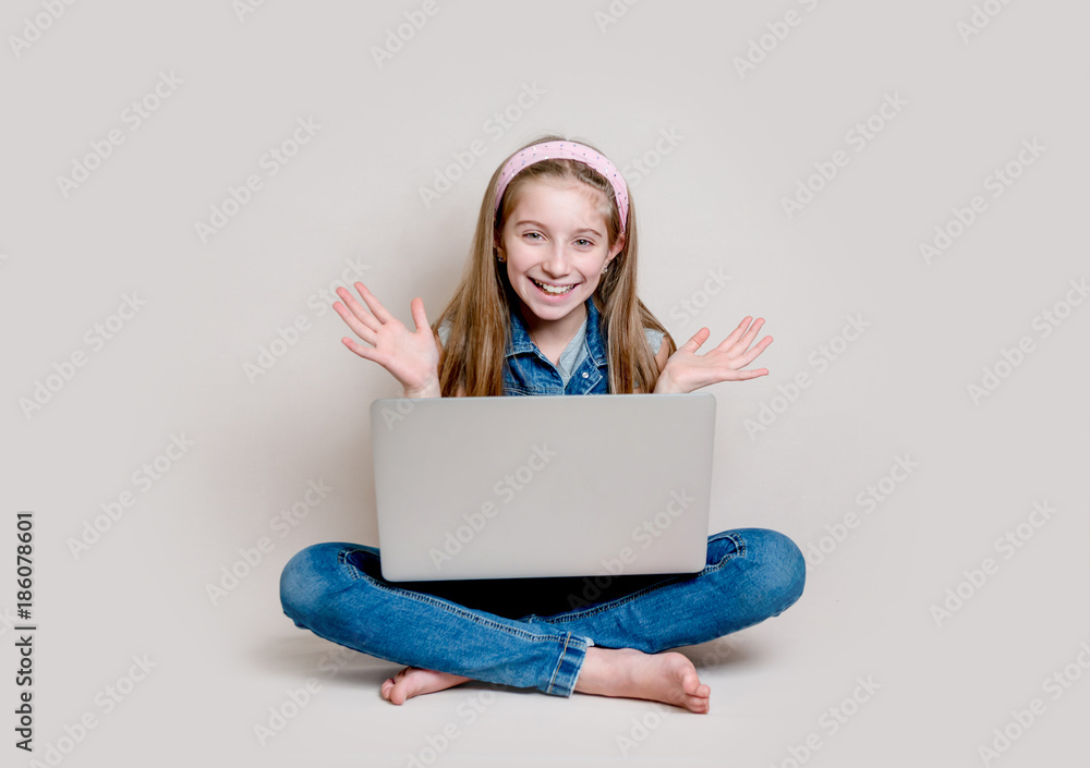 Cheerful little girl sitting on the floor with laptop Cheerful little girl sitting on the floor with laptop