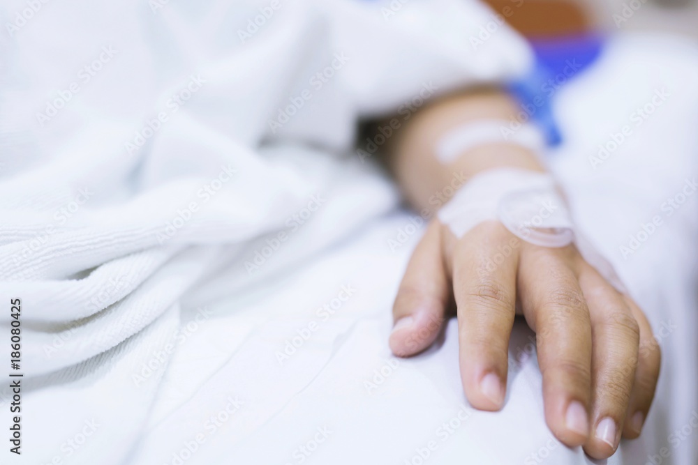 close up focus on the hand of a patient sick on the bed in hospital ward. close up focus on the hand of a patient sick on the bed in hospital ward.